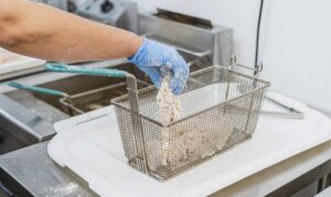 Professional breading system for foodservice Chicken pieces being coated with professional breading mix in a restaurant kitchen